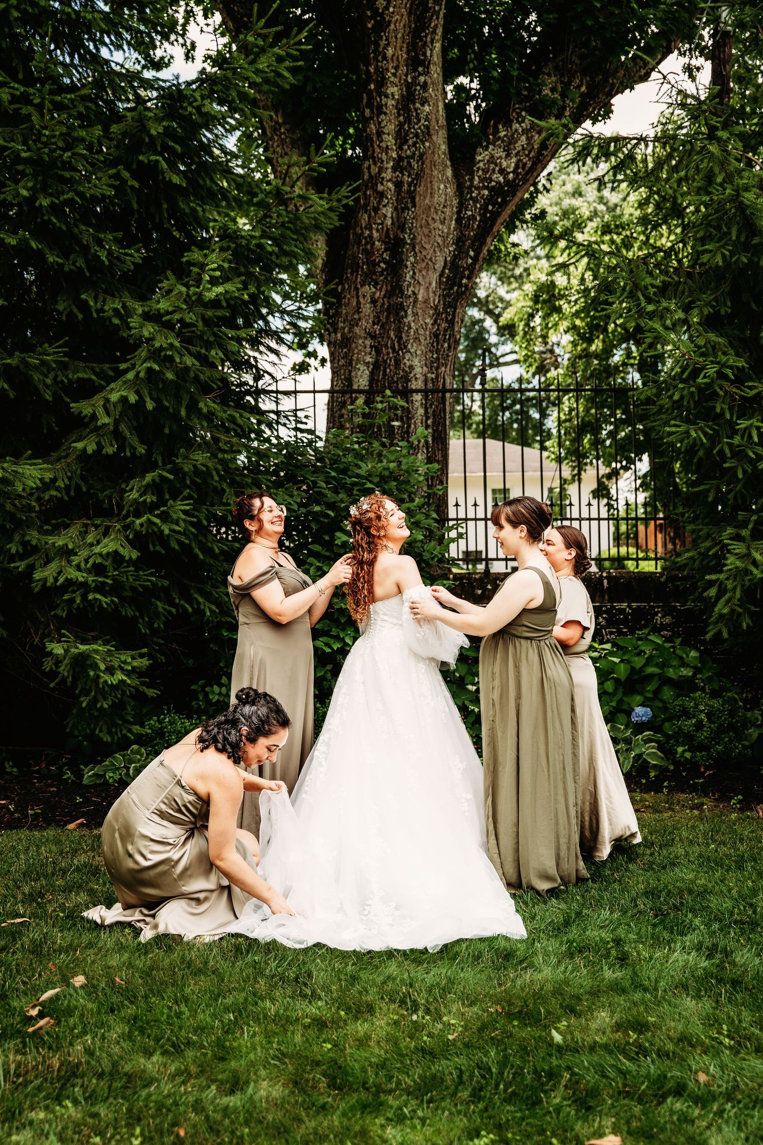 Bridesmaids primp and pamper the bride on the lawn of Highgate Carriage House in Fairmont, WV