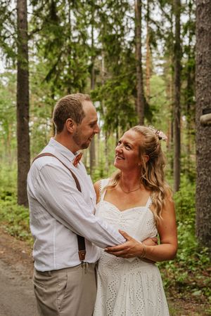 Brudpar ser kärleksfullt på varandra under sin bröllopsfotografering i Ockelbo