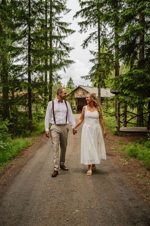 Brudpar går tillsammans under sin bröllopsfotografering i Ockelbo
