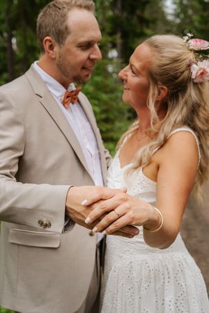 Brudpar ser kärleksfullt på varandra under sin bröllopsfotografering i Ockelbo