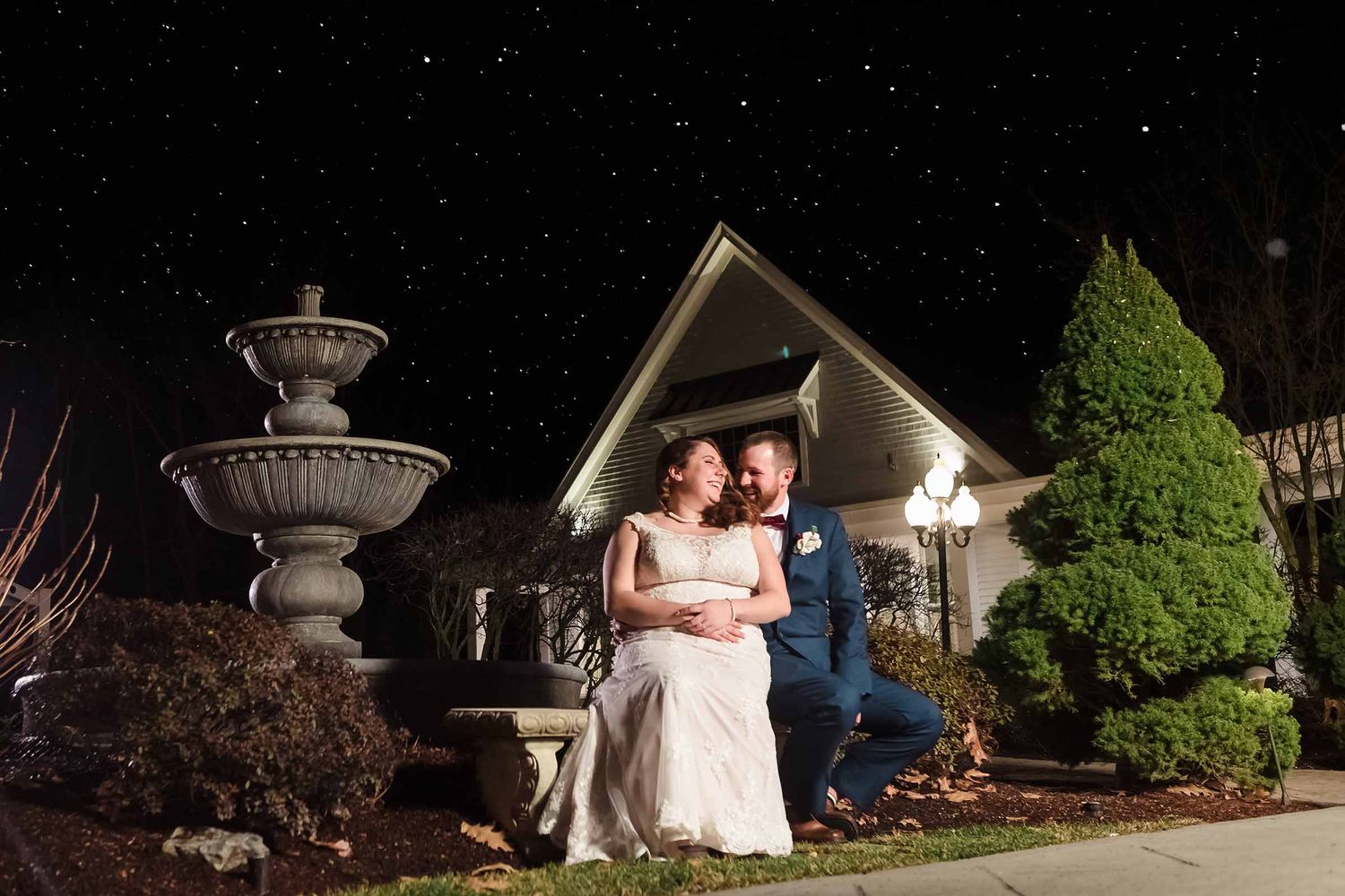 Bride and groom laughing together under a starry night sky after their wedding ceremony ran late and daylight portraits weren't possible