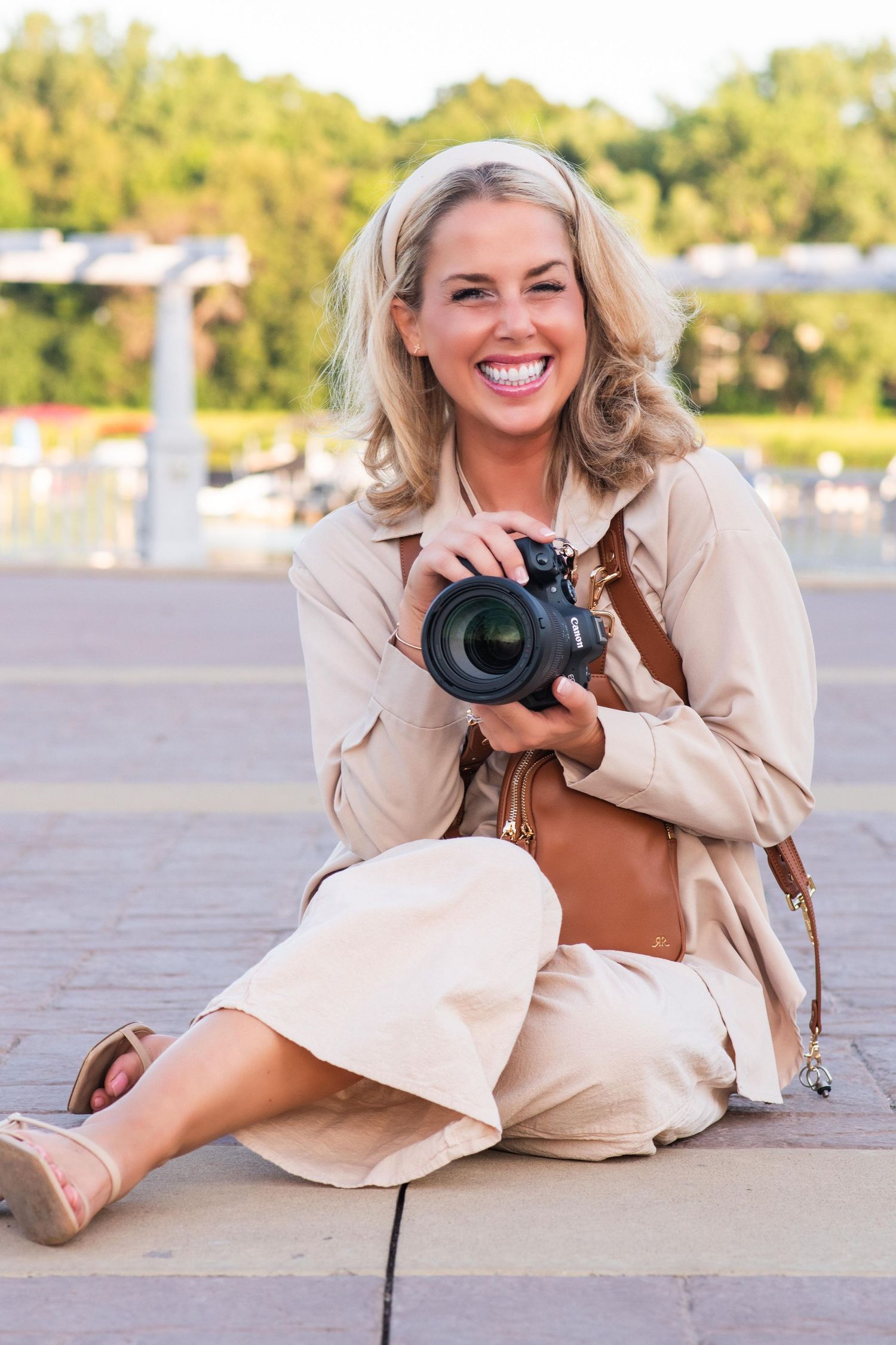 Candid outdoor portrait of photographer Danielle Taylor with her camera, showcasing her natural, documentary lifestyle media brand.