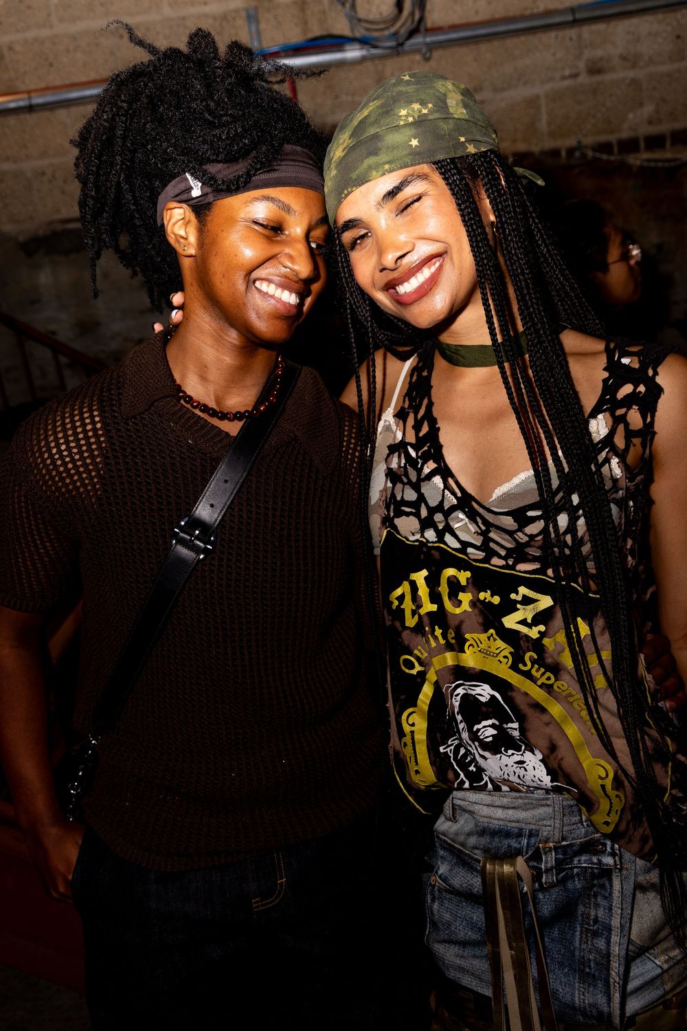 Nightlife photography of two smiling lesbians in Brooklyn, NYC by trans dyke photographer Kade Joy.