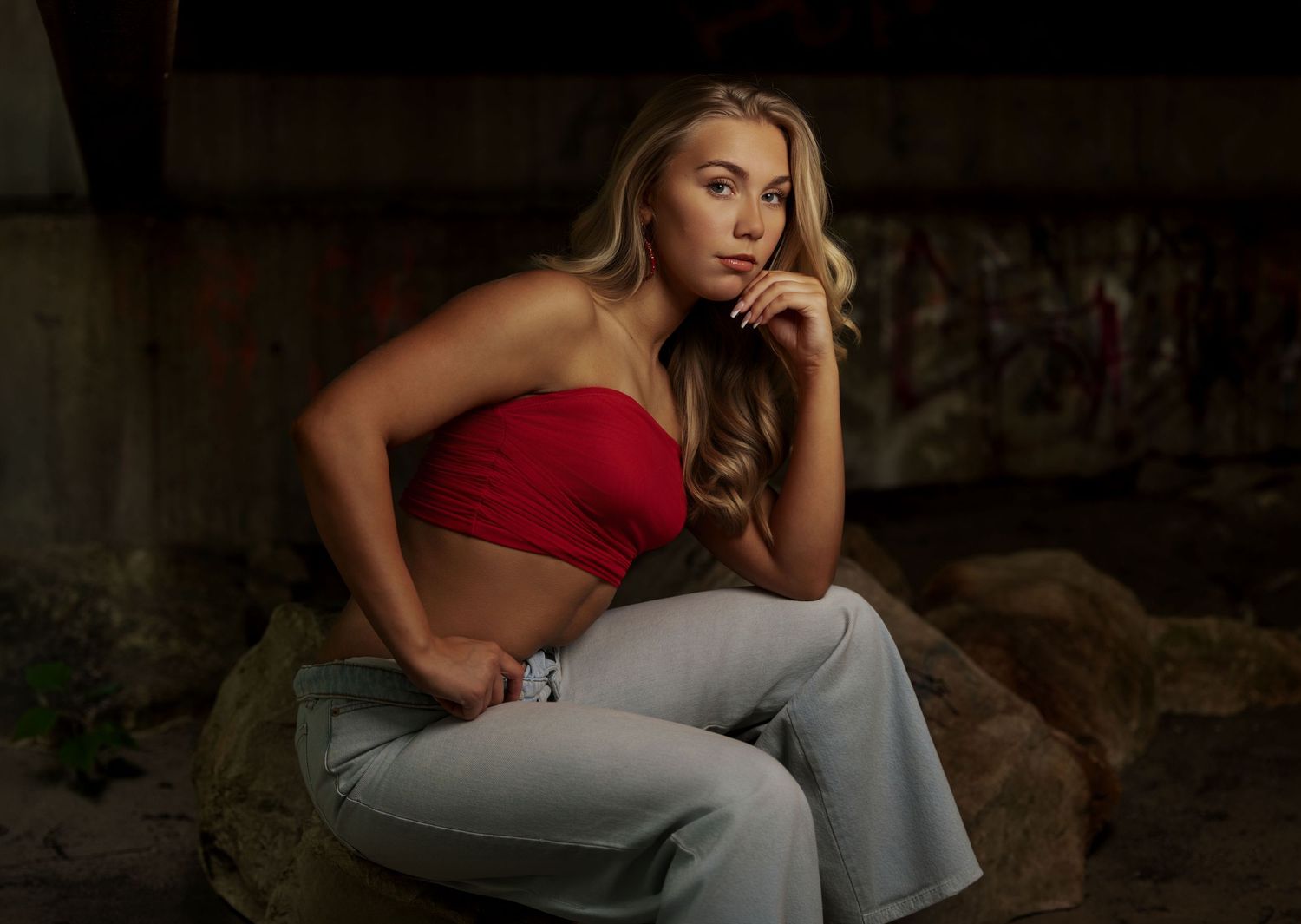 Senior portrait of a blonde girl in a red top photographed in a rustic setting