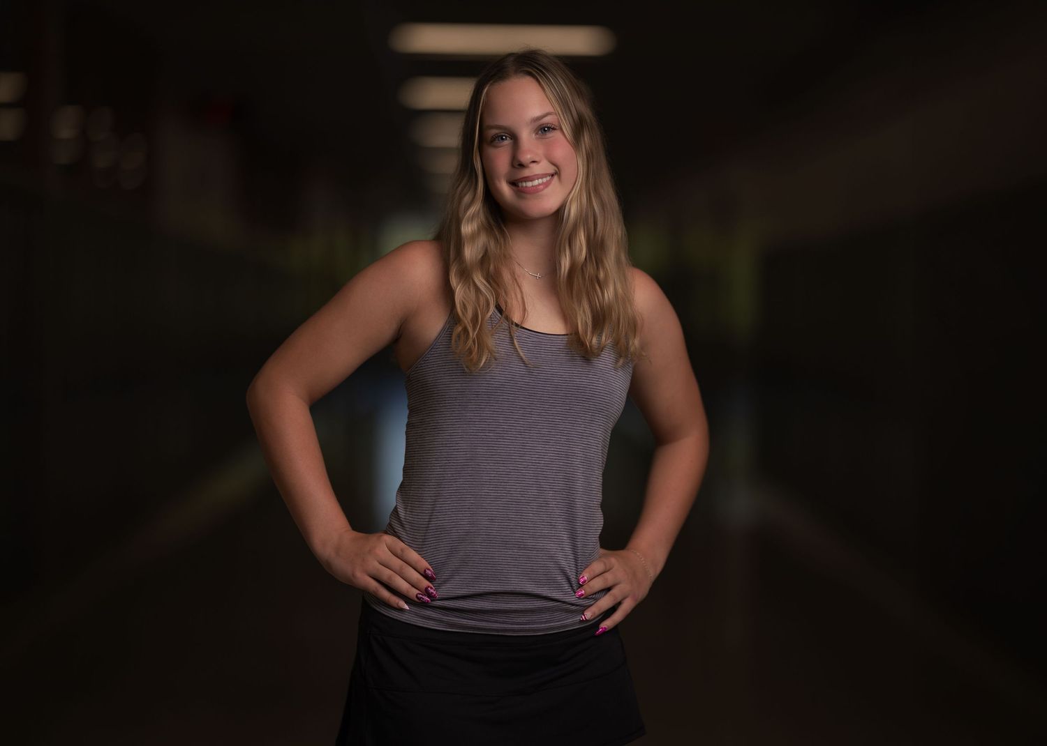 Senior portrait of a smiling blonde girl photographed with dramatic lighting