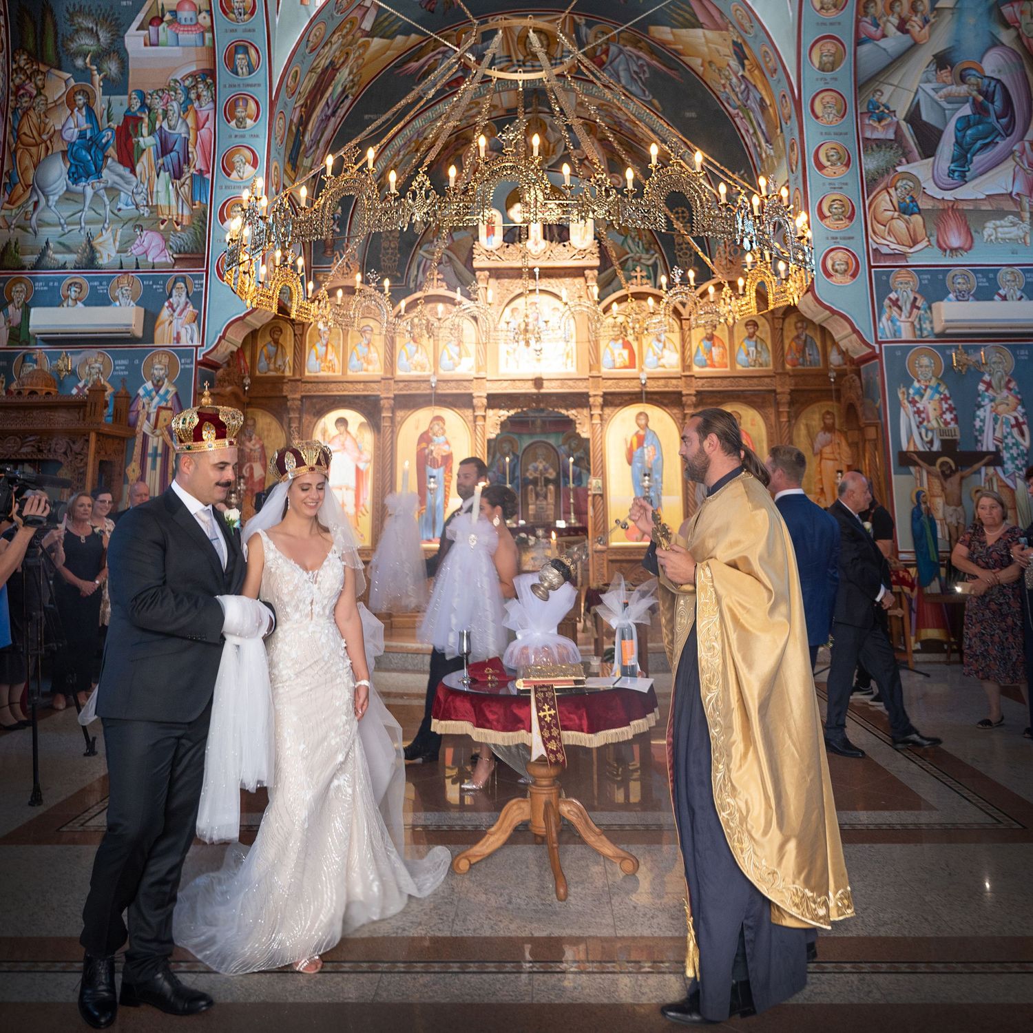 Coptic Orthodox bishop swings golden incense thurible during a traditional religious wedding ceremony.