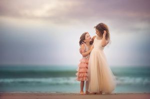 Two girls posing together for a beach portrait session in Cape May, New Jersey.