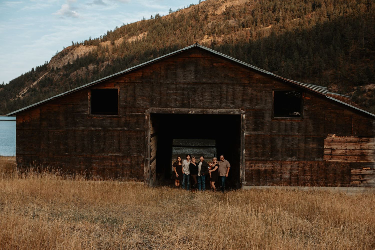 Okanagan family photography session at a rustic barn surrounded by golden grass and mountains near Penticton, BC.
