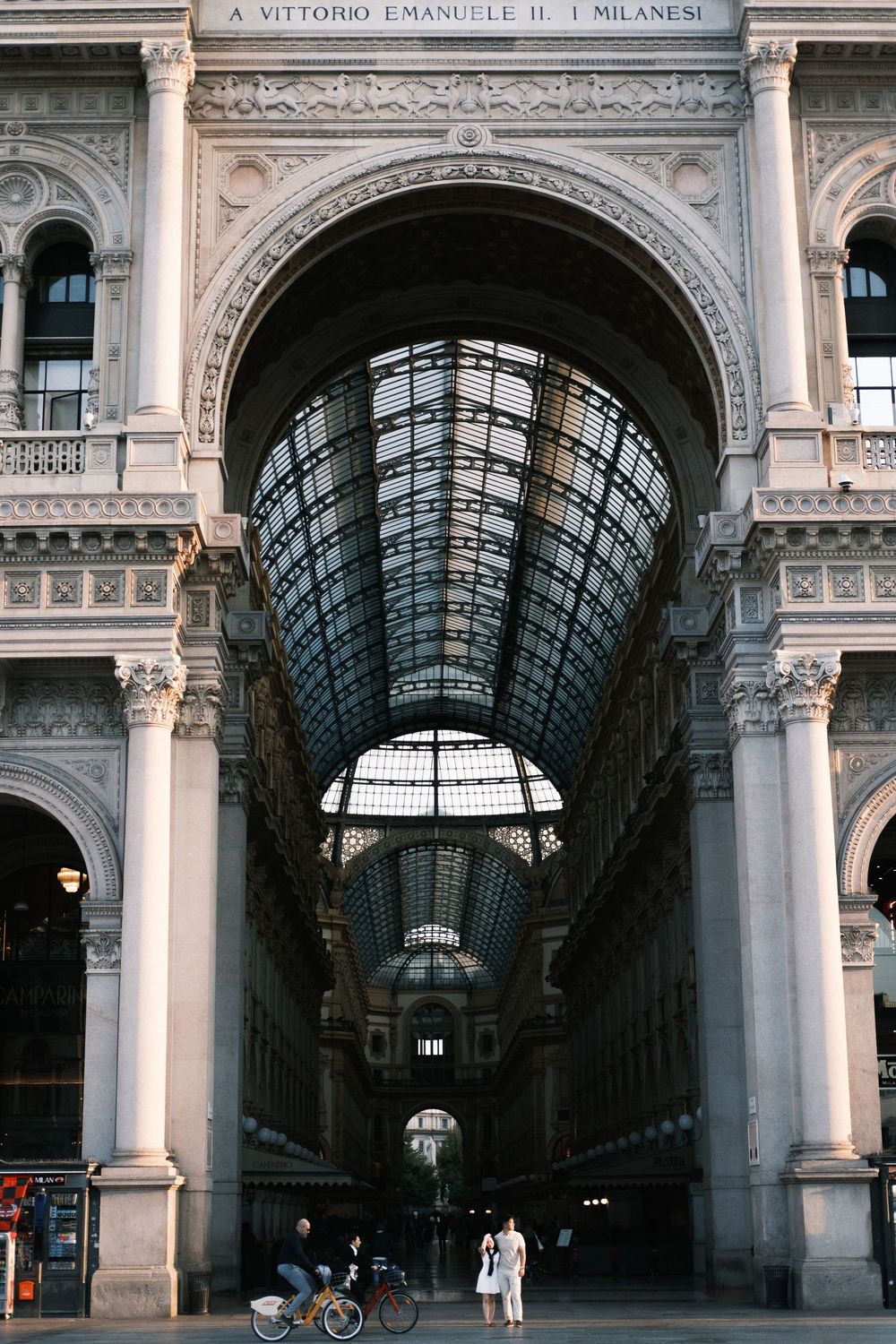 Grand arched entrance of Galleria Vittorio Emanuele II in Milan, Italy, featuring ornate architecture and glass ceiling.