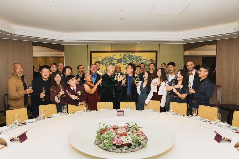 Large group of professionals toasting at a formal dinner banquet in an elegant private dining room.