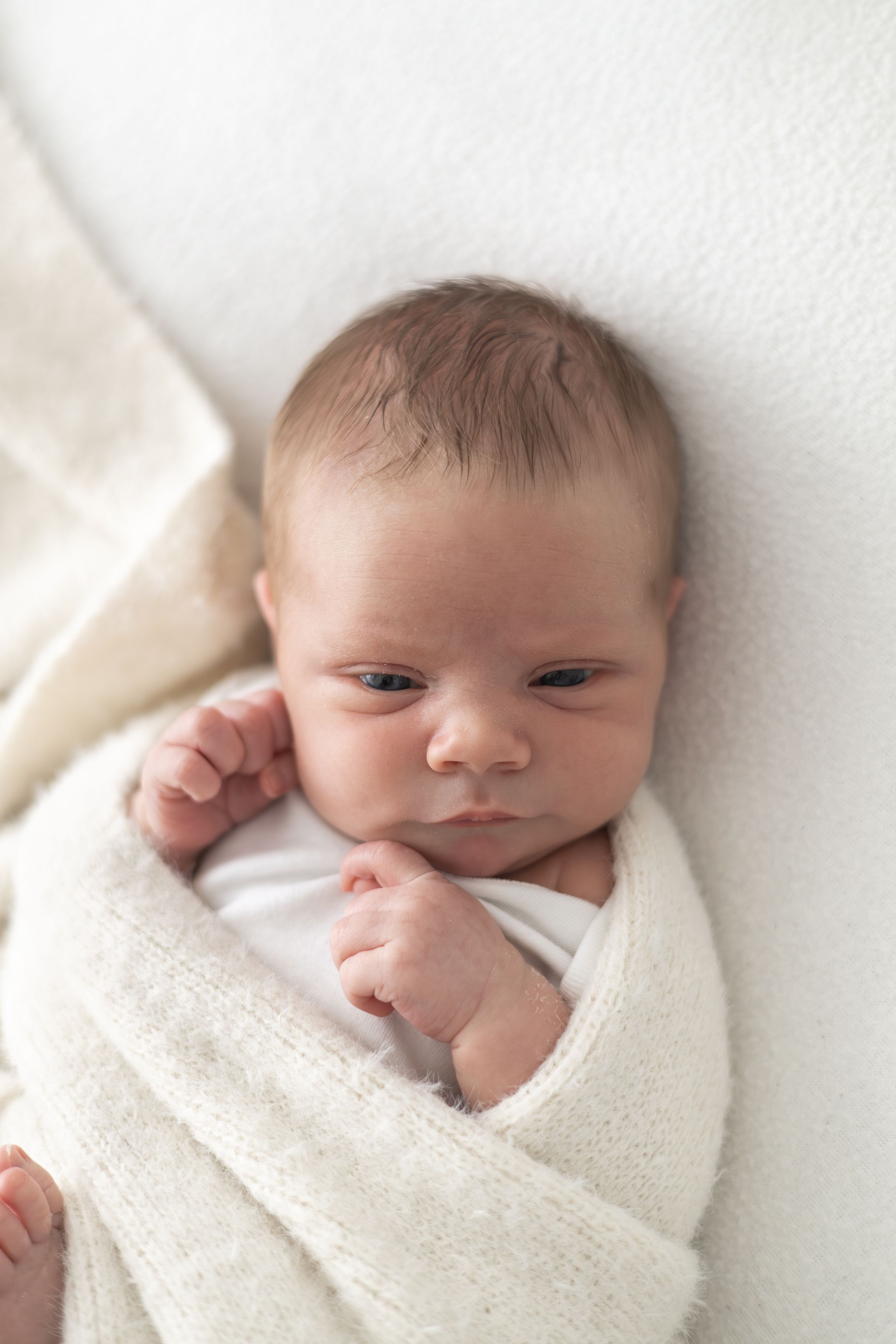 Awake newborn baby looking towards the camera during a natural photoshoot