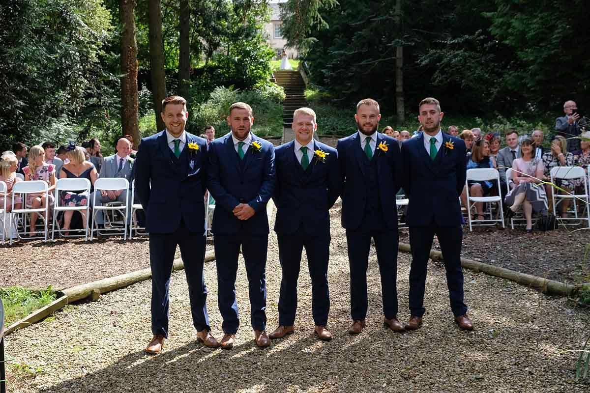 The Groom & four groomsmen in navy suits await the brides arrival at the outdoor wedding celebration at Blaithwaite House