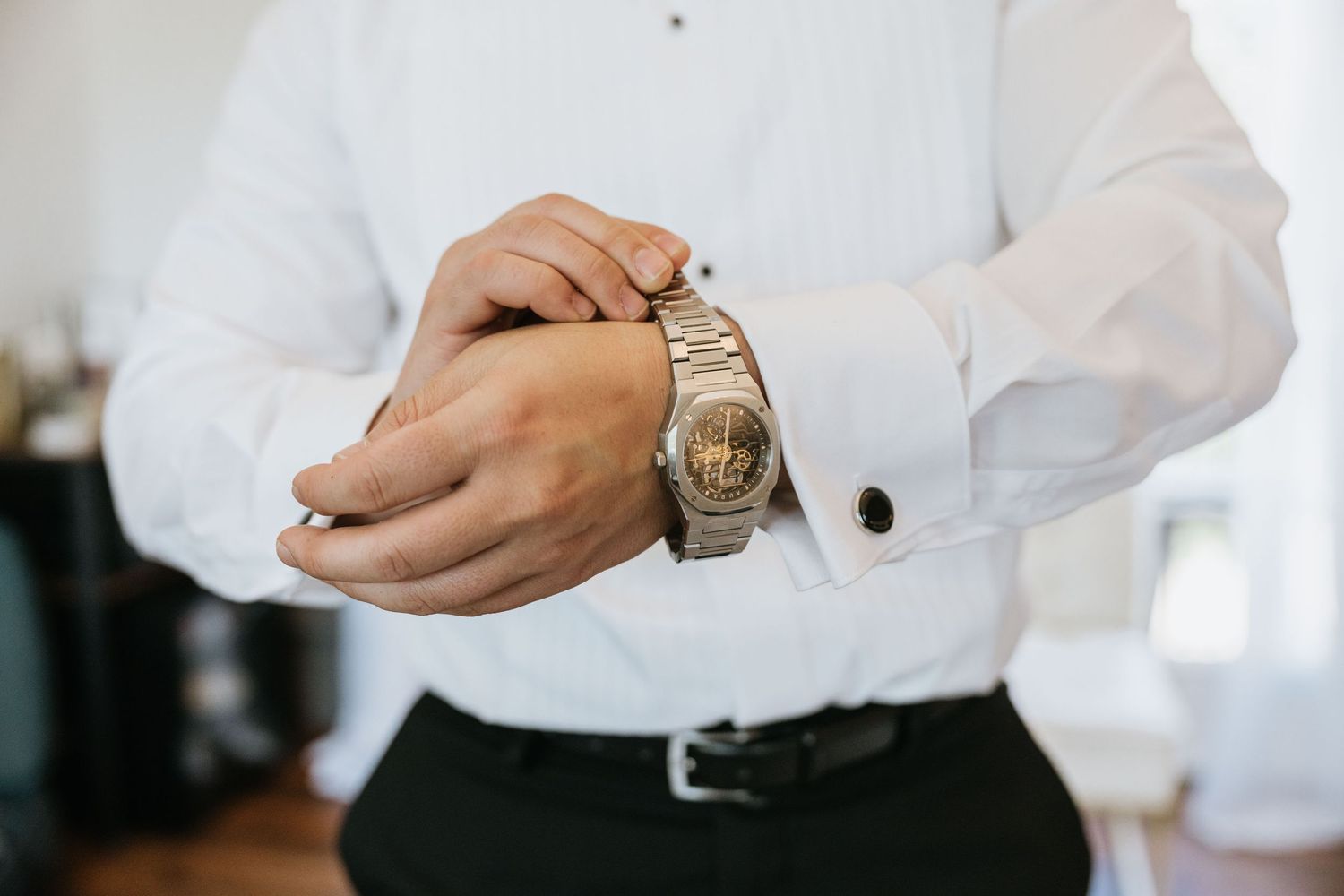 Paul adjusting his watch while getting ready