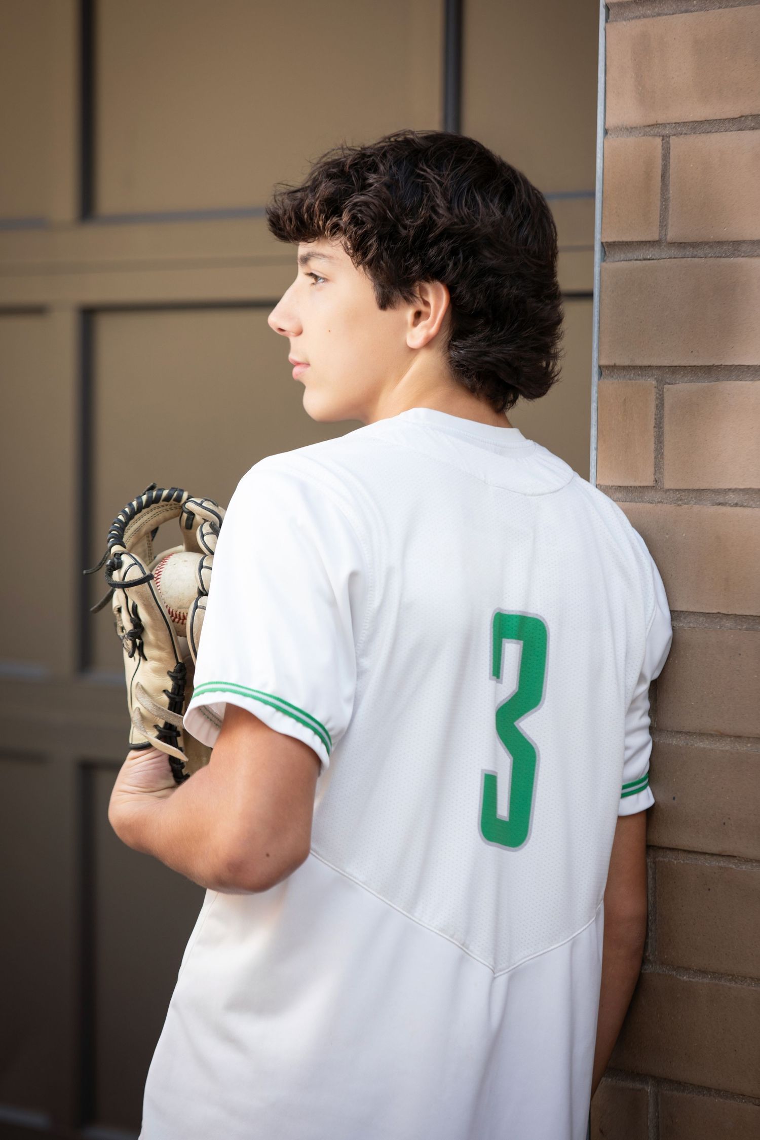 Dublin Scioto baseball senior photos at Bridge Park with varsity jersey, glove, and modern urban Columbus backdrop.