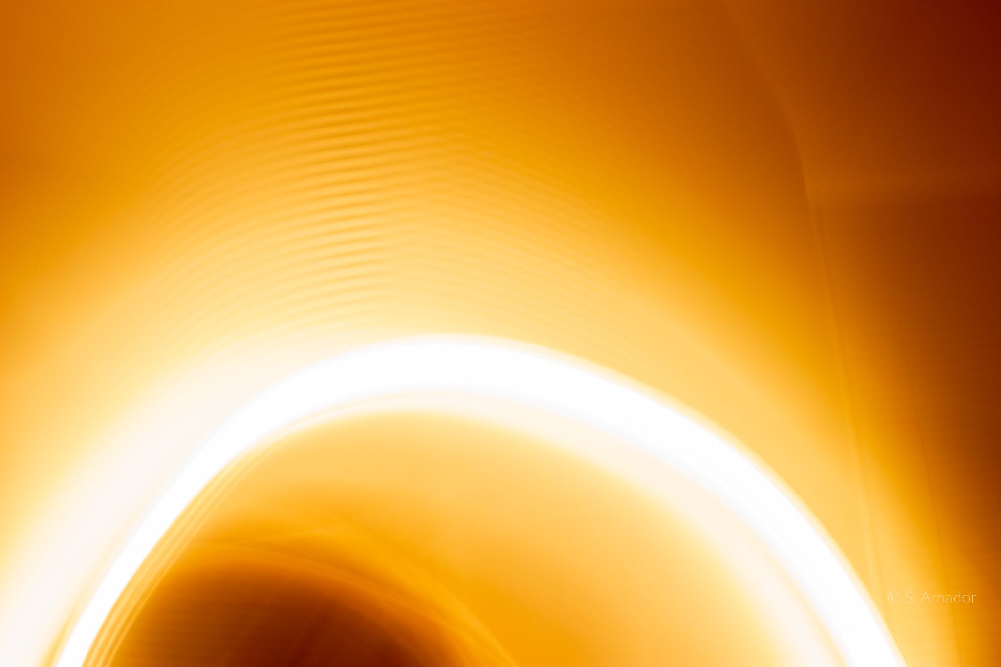 Abstract golden orange glowing light curve wave background, warm luminous artistic design.