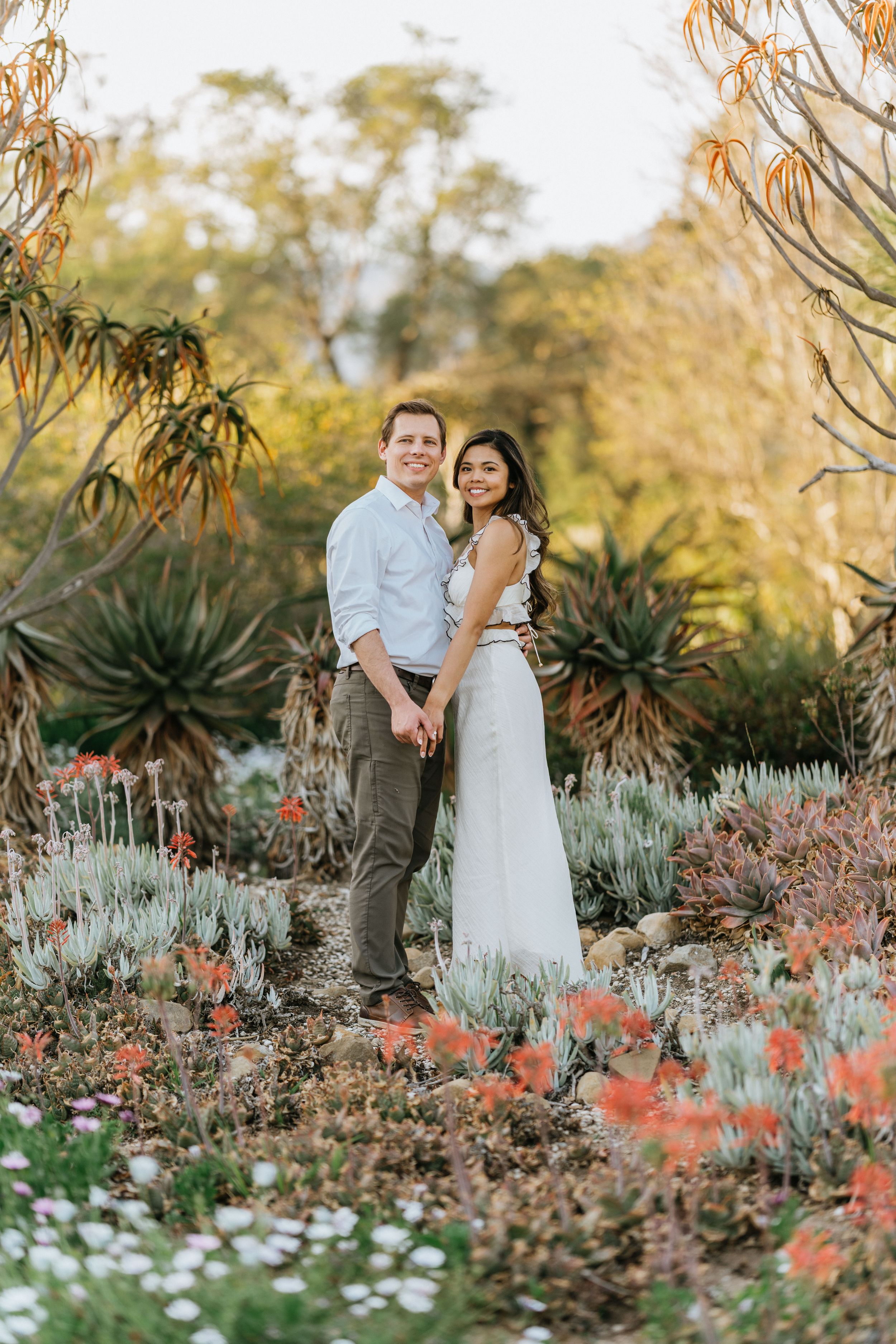 Mariel and Jeff standing together in the Arboretum's desert garden landscape.