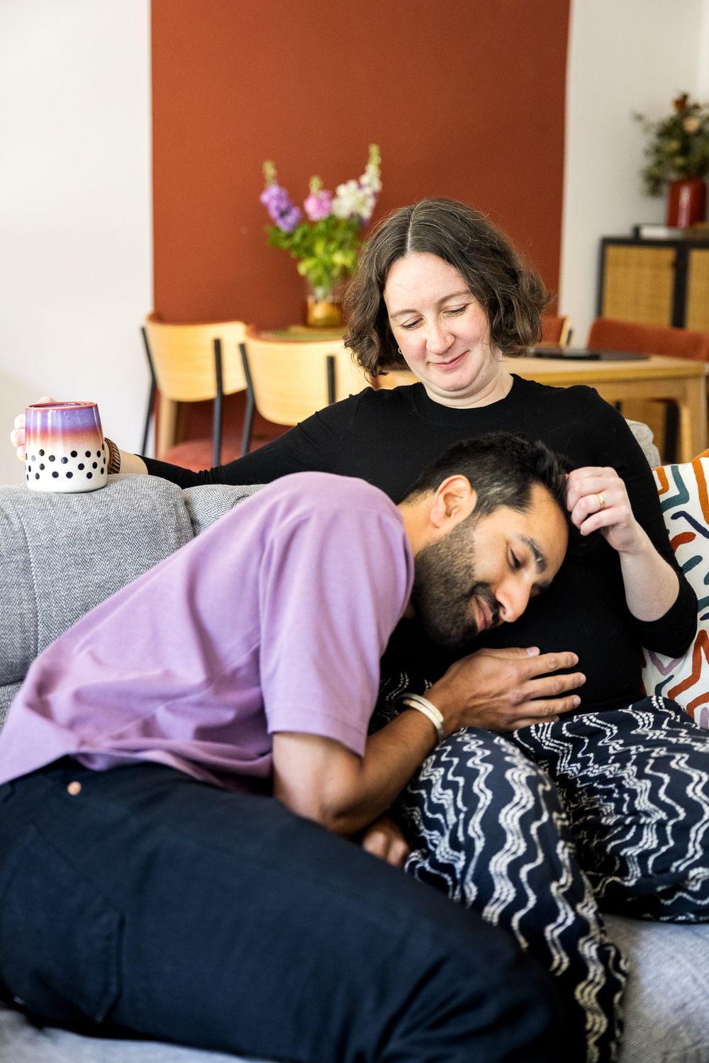 husband listening to pregnant wife belly