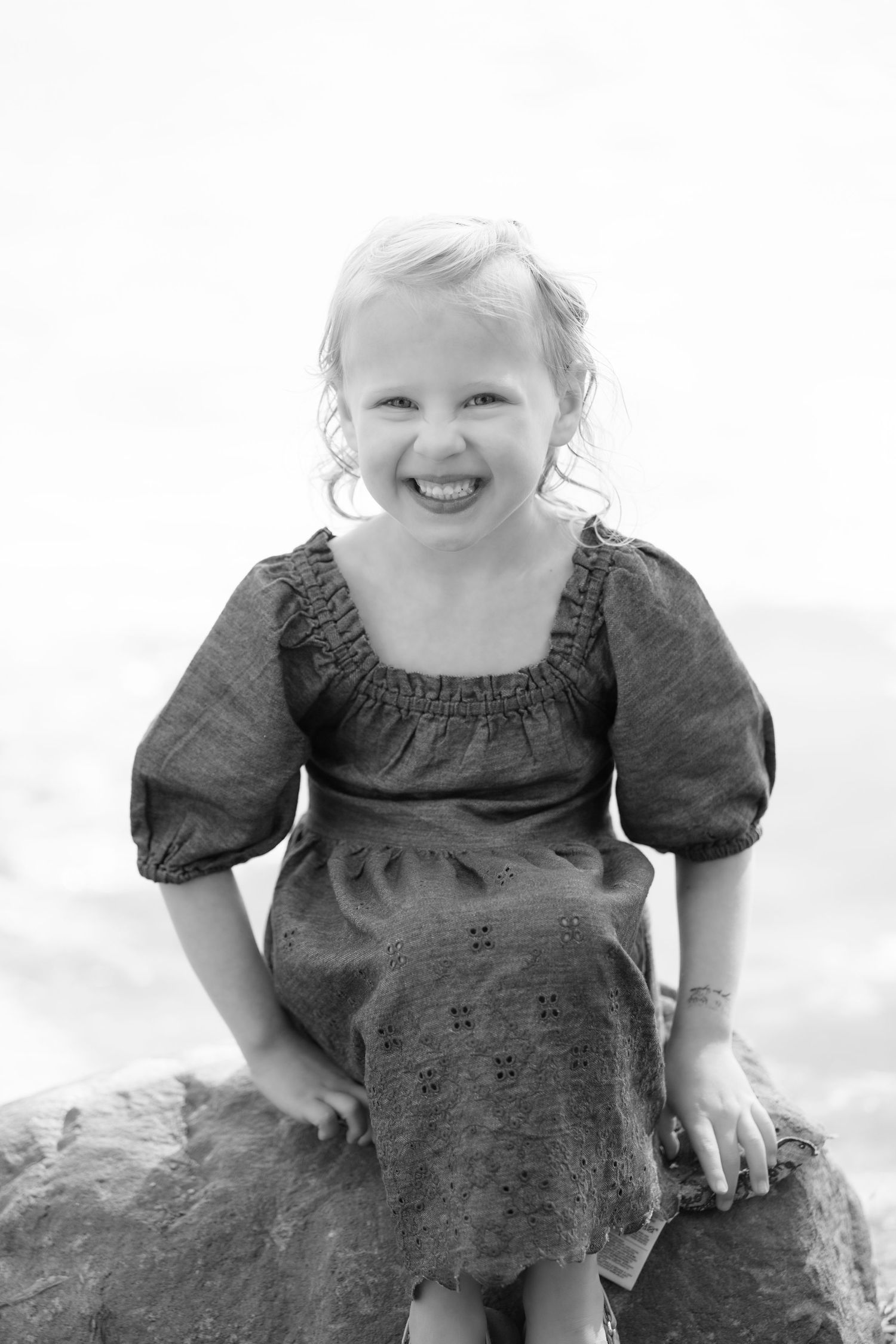 black and white headshot of grandchild with a big cheesy smile during extended family portrait session at powers lake park in woodbury mn