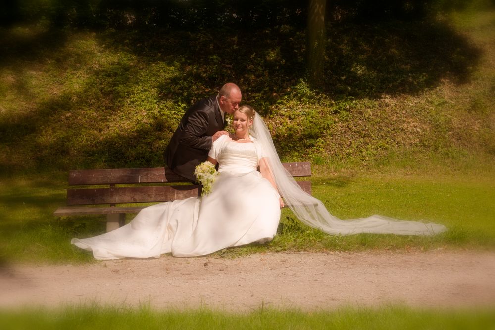 Braut und Bräutigam halten Händchen während eines Shootings im Stadtpark Forchheim. Emotionale Brautpaar-Bilder im Freien.