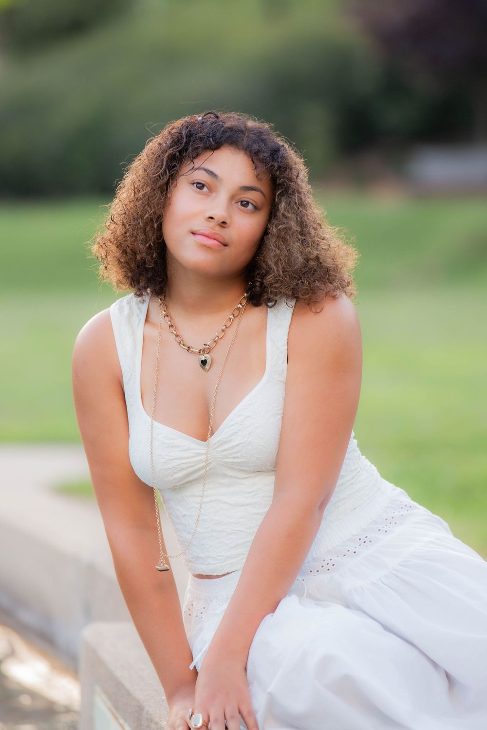 Ethereal portrait session featuring a white summer dress in a sun-dappled garden landscape.