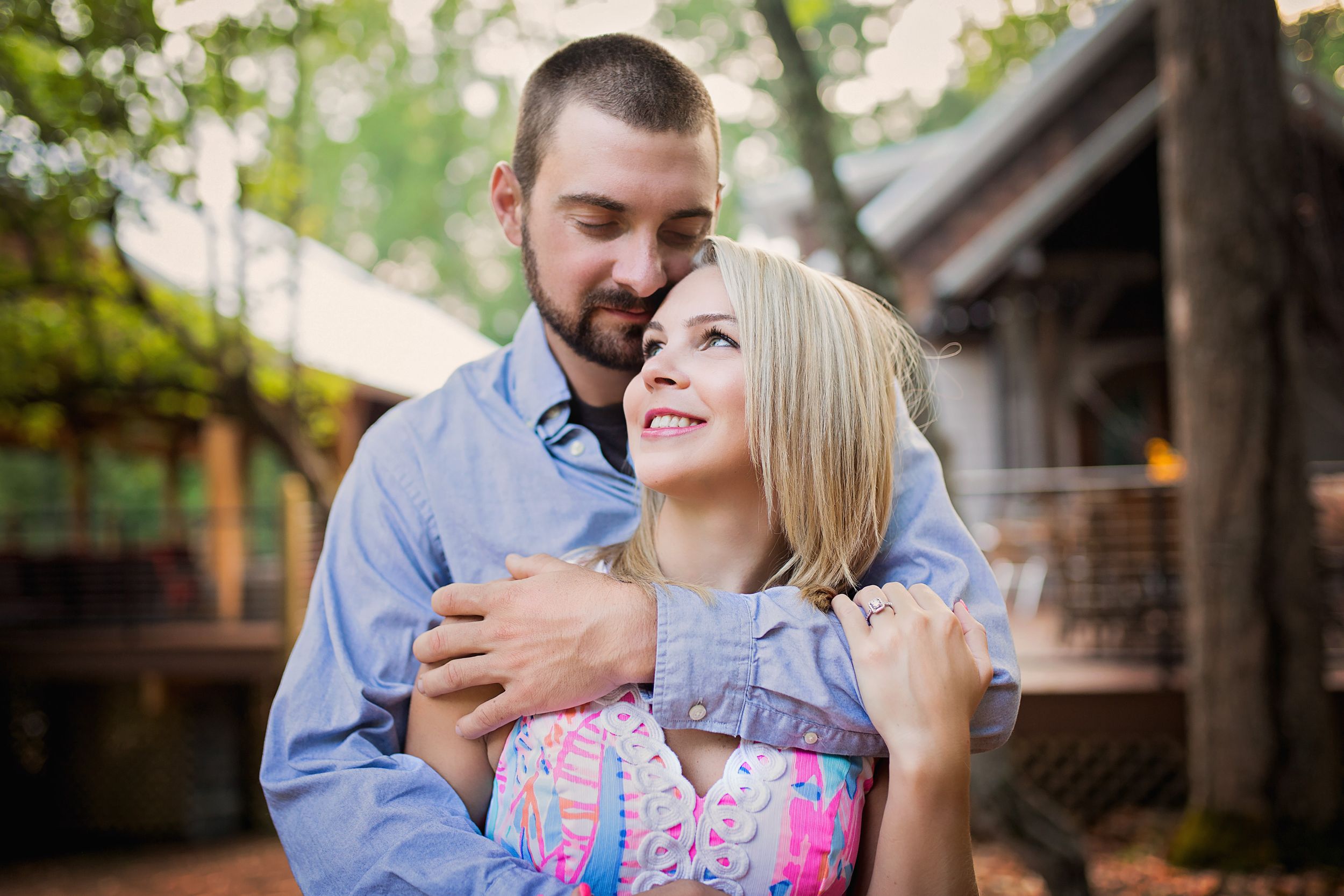 A romantic outdoor moment showing a loving embrace as a couple shares a joyful laugh together.