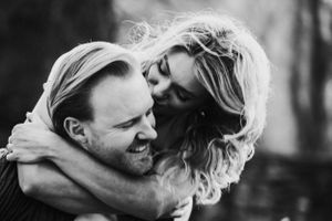 An intimate black and white portrait capturing a couple embracing and sharing a joyful moment.