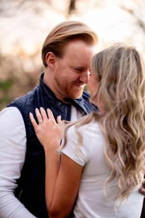 A tender moment between a couple laughing and embracing outdoors during golden hour.