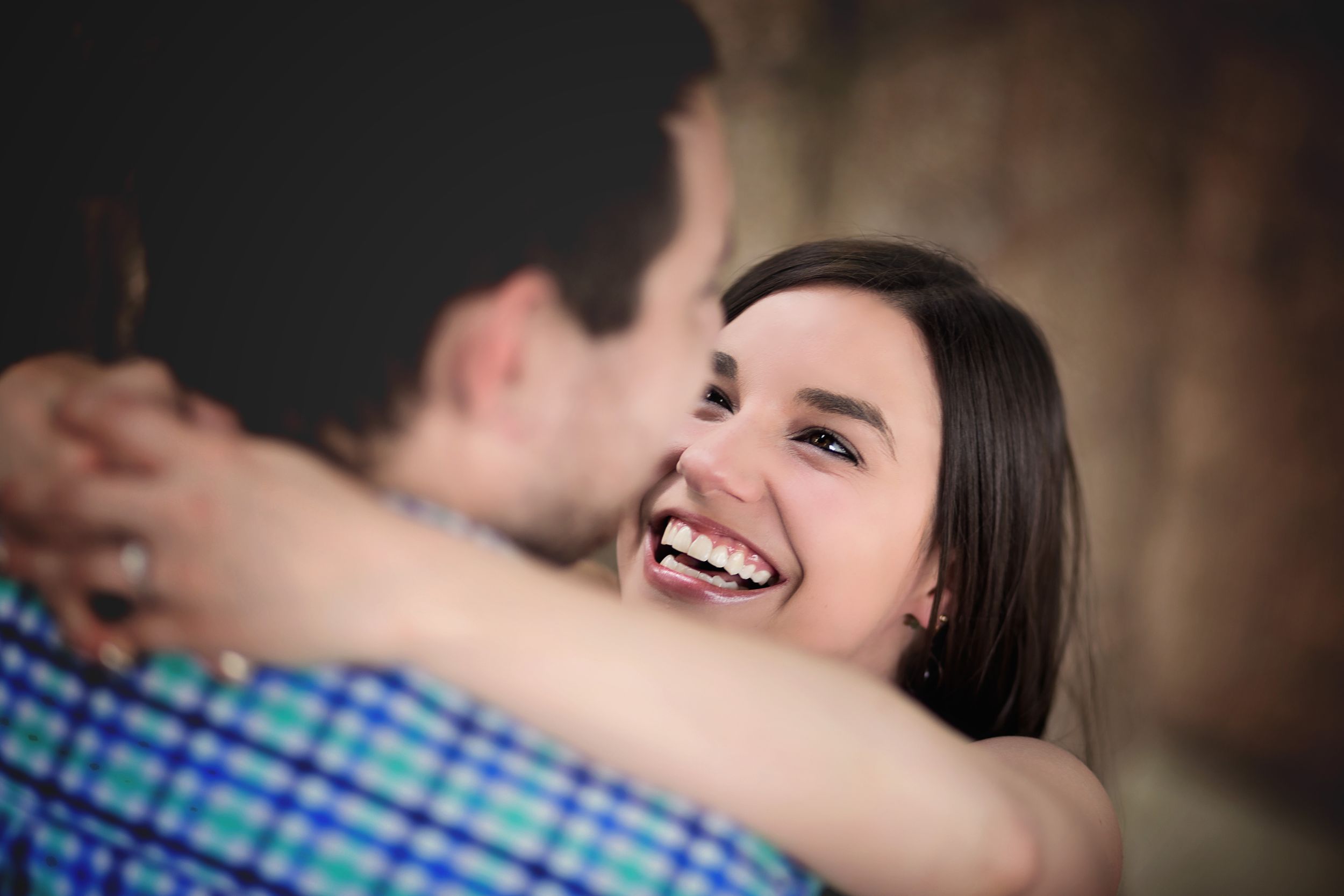 A candid moment captures pure joy and laughter during an embrace.
