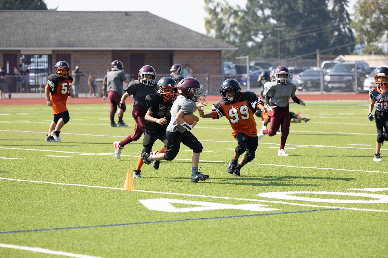 Youth football players competing during a game on an outdoor field.