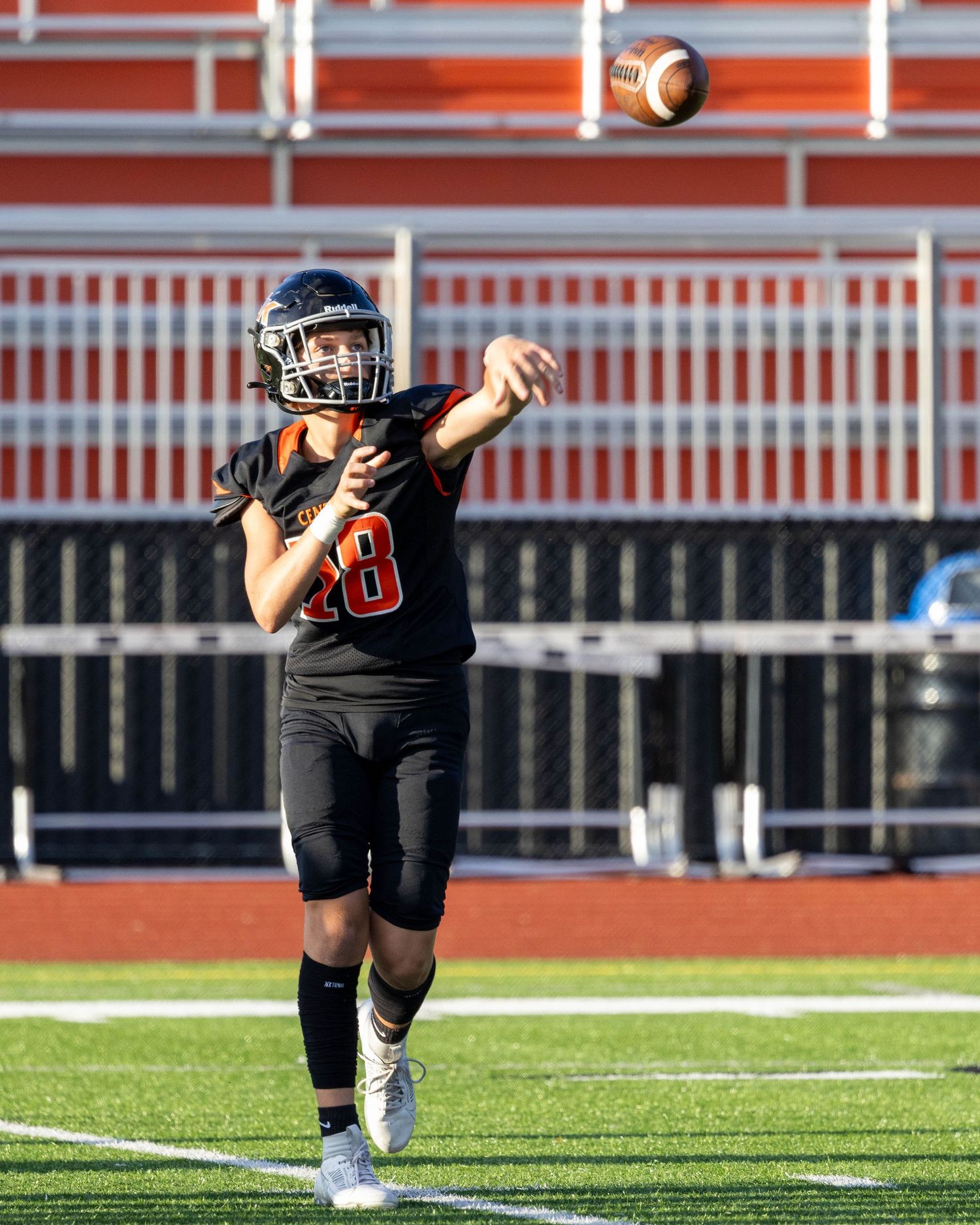 Football player in black uniform throwing a pass during a game.