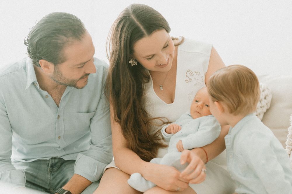 Family sharing joyful moment together on white couch.