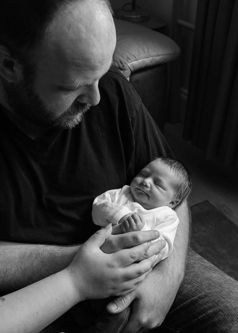 parents with newborn baby in an in home newborn photo session in edinburgh lothian hospital
