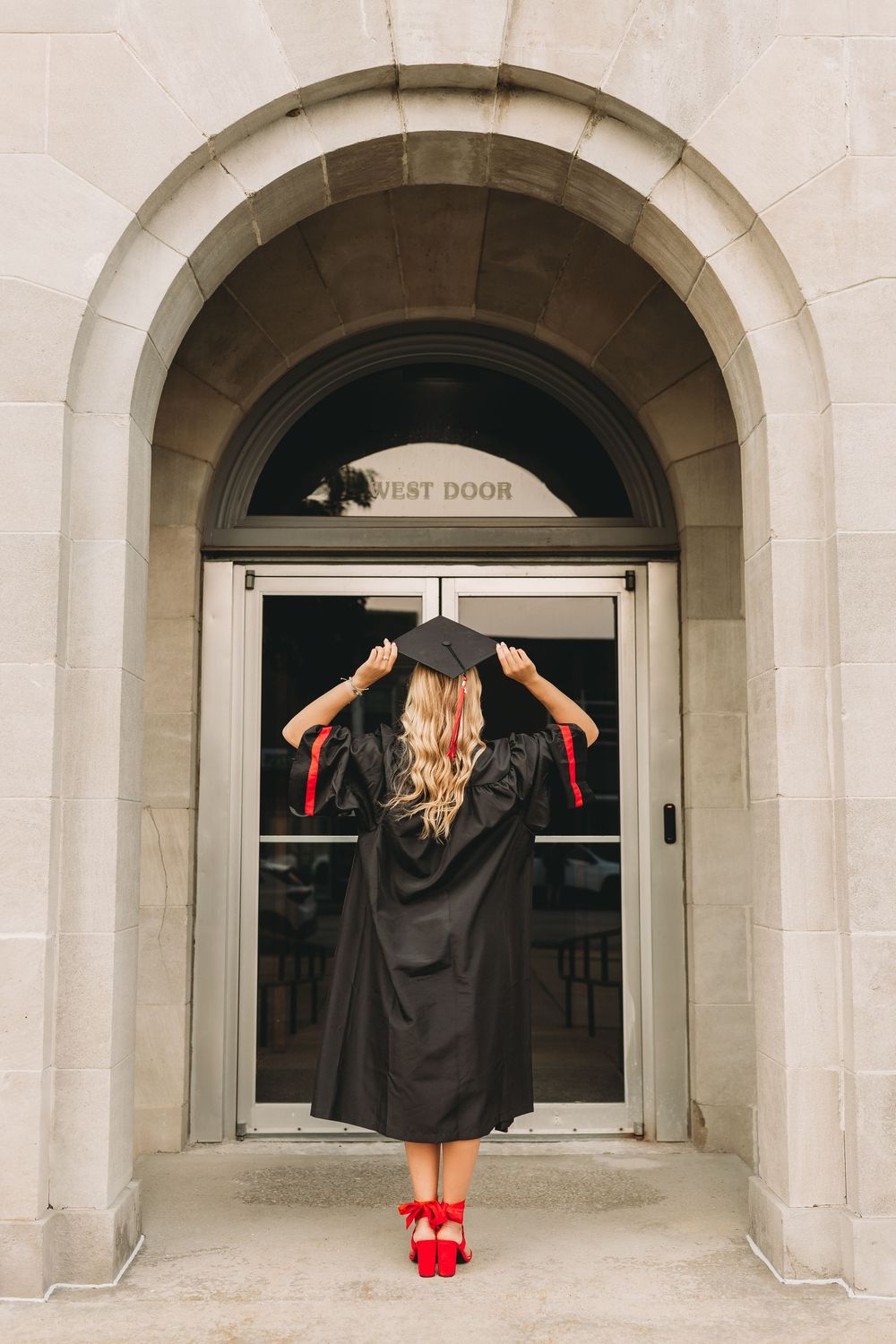 senior graduate girl blonde hair white dress black cap and gown red tassel red high heals