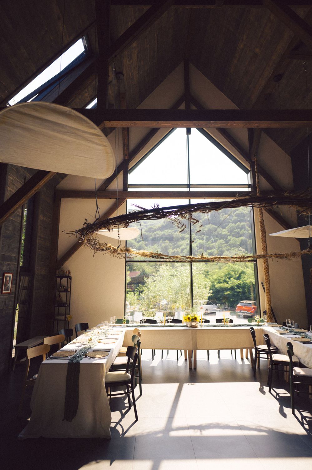 Modern dining room with vaulted ceiling and large window overlooking mountain landscape.