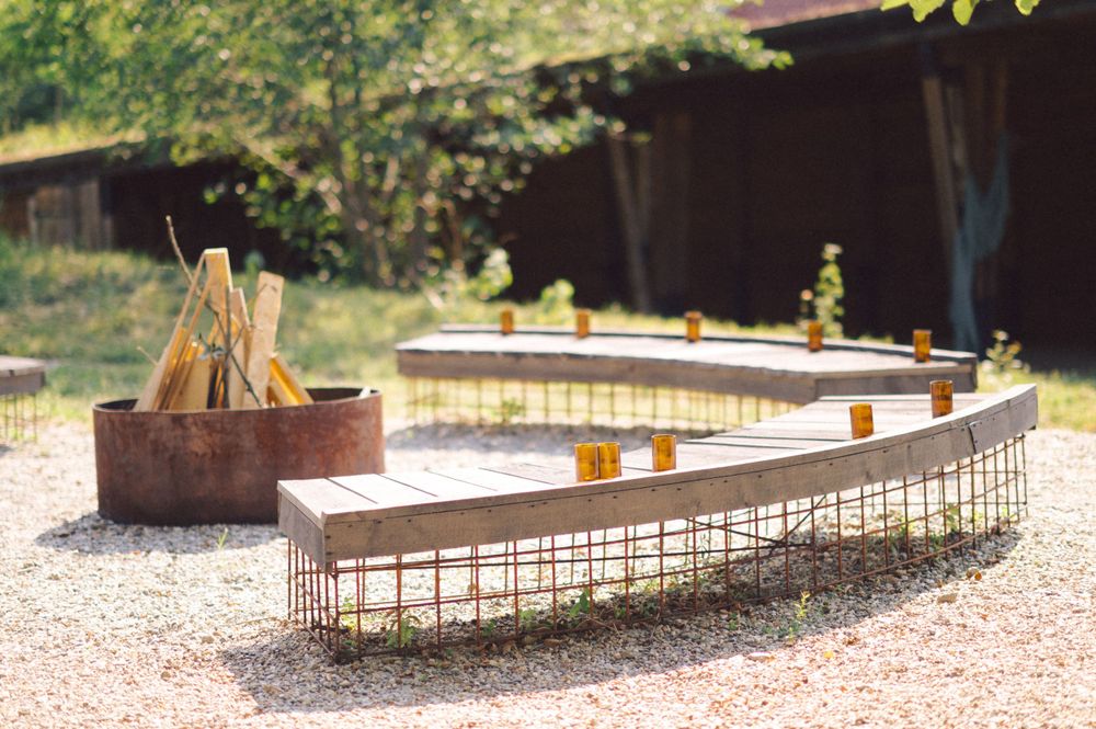 Curved bench and fire pit arrangement in outdoor gravel patio area.
