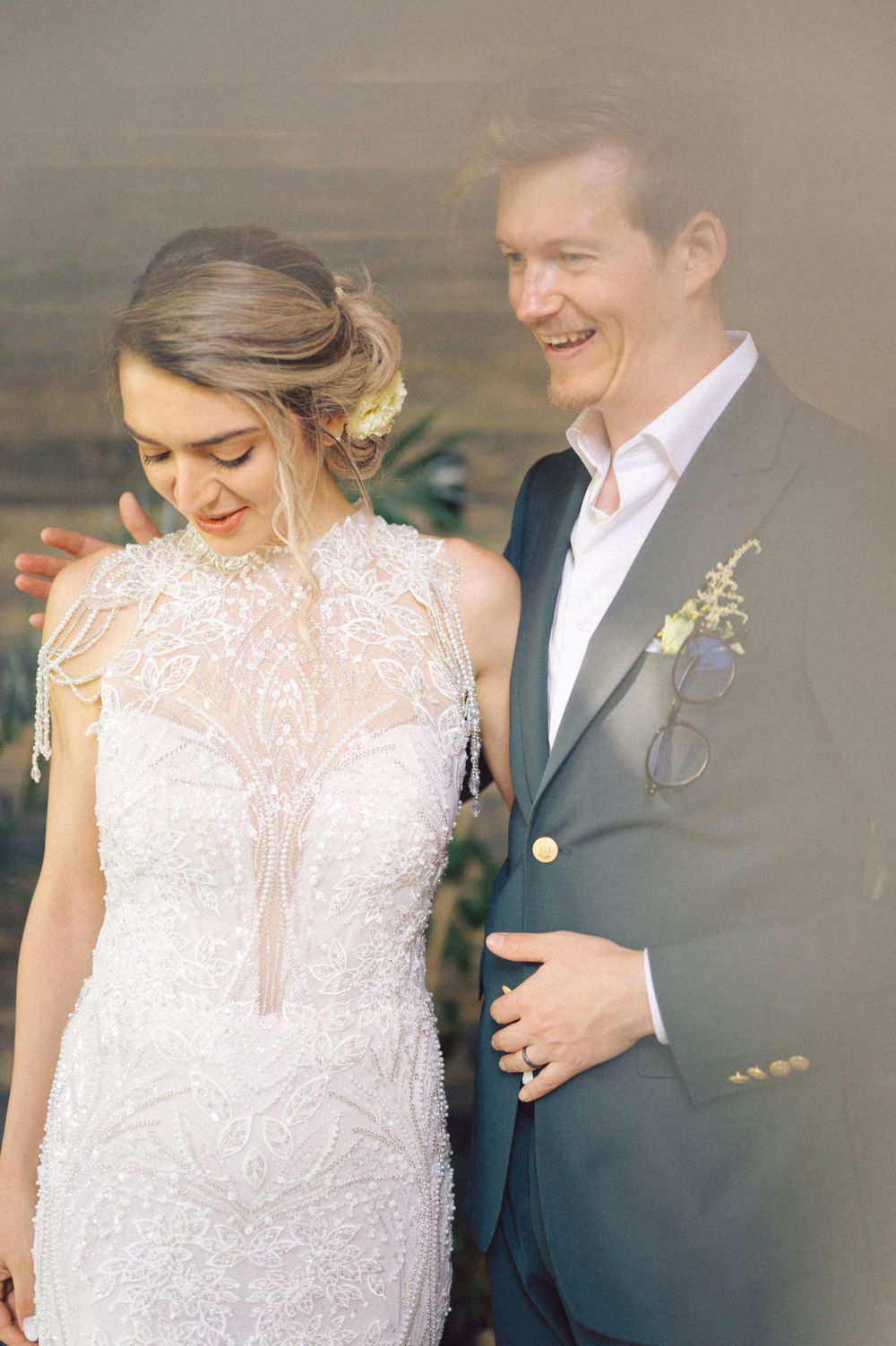 A tender moment between a couple in wedding attire with natural lighting.