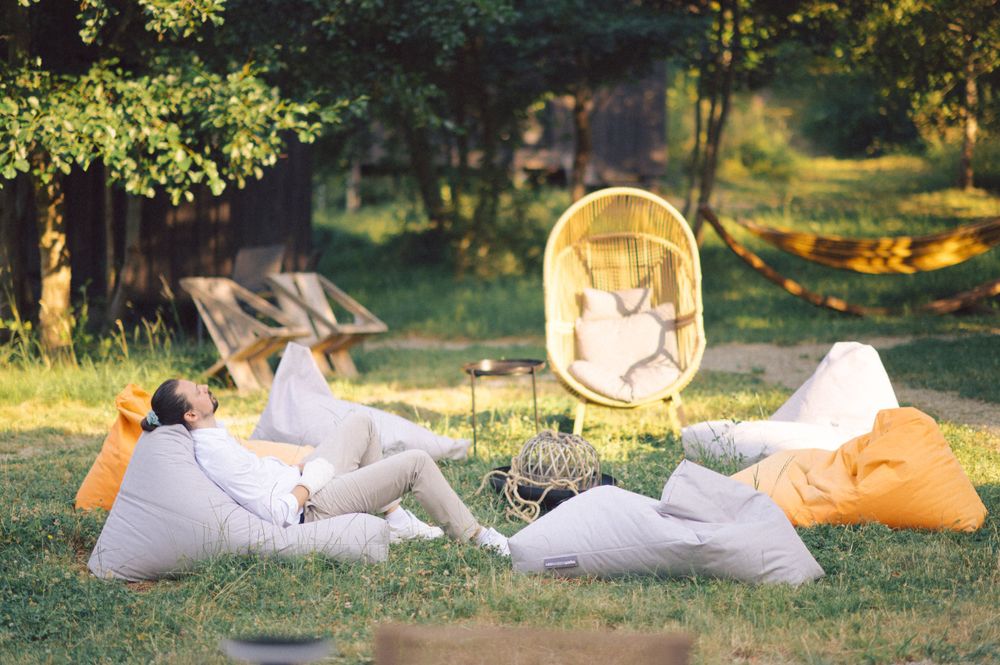 People relaxing on bean bags in a sunny garden setting.