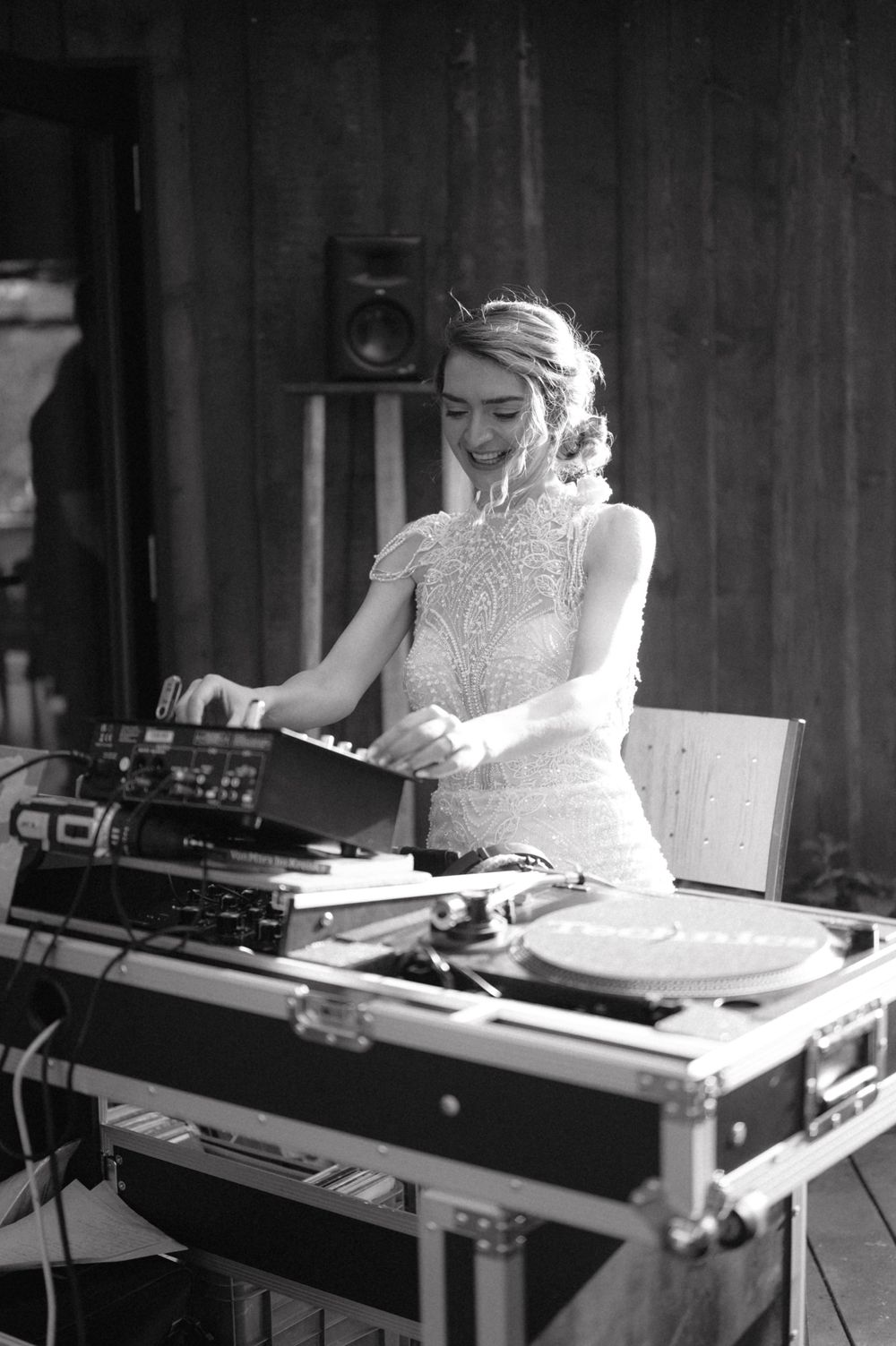 DJ equipment setup at a rustic barn wedding venue in black and white.