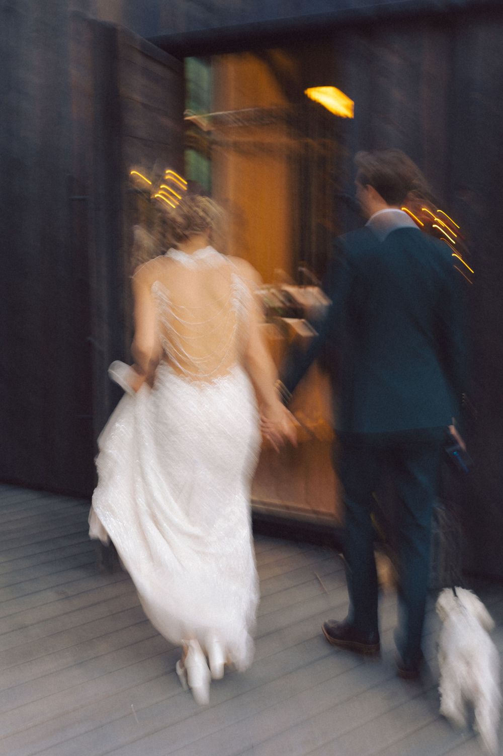 A blurred motion shot of two people entering a doorway in formal attire.