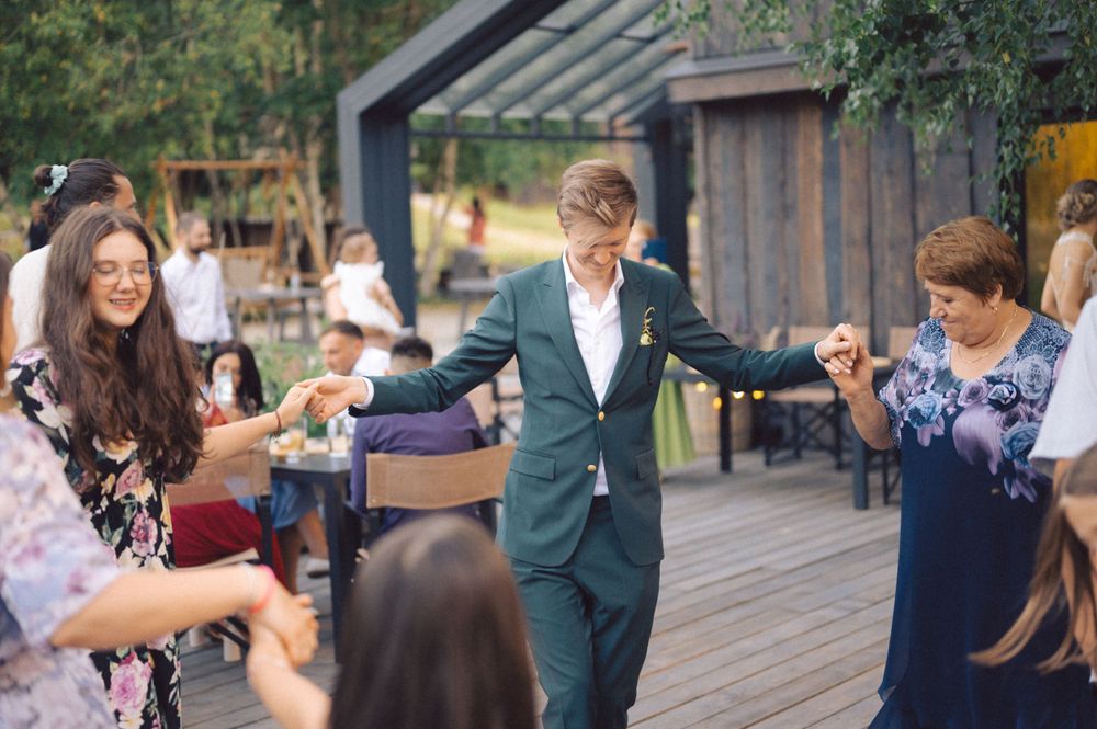 Guests dancing and celebrating on a wooden deck during an outdoor party.
