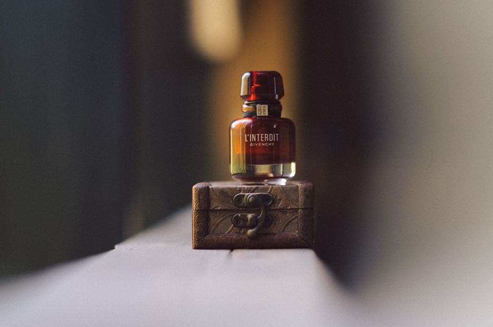 A small brown bottle of liquor sits on a stone block in moody lighting.