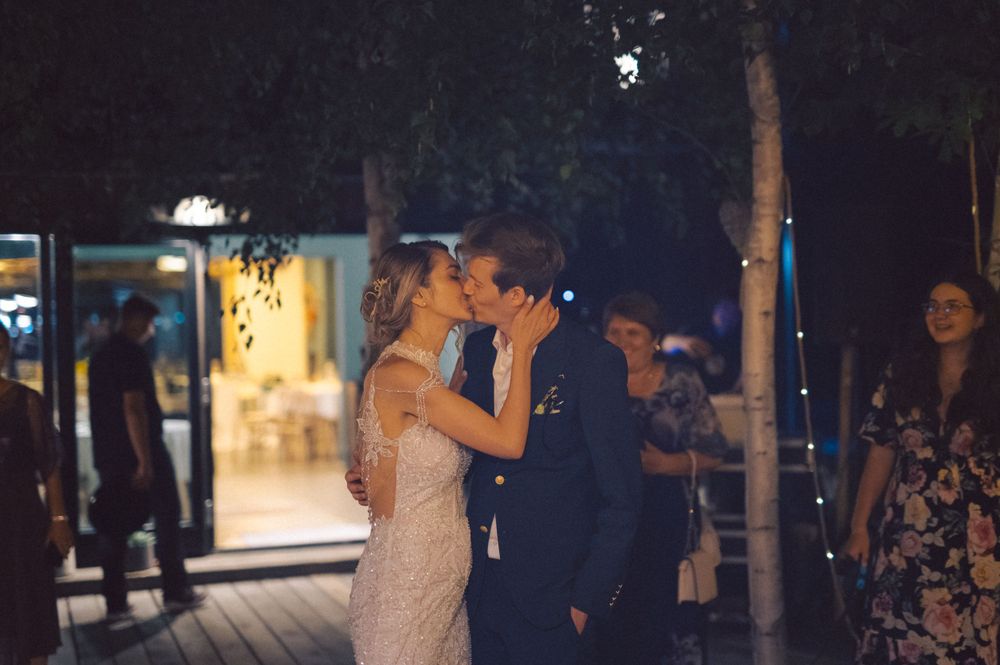 A romantic moment shared between newlyweds during their evening outdoor celebration.