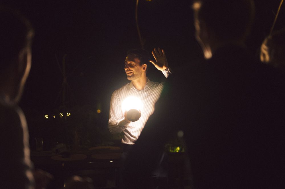 A figure illuminated by candlelight during a nighttime celebration.