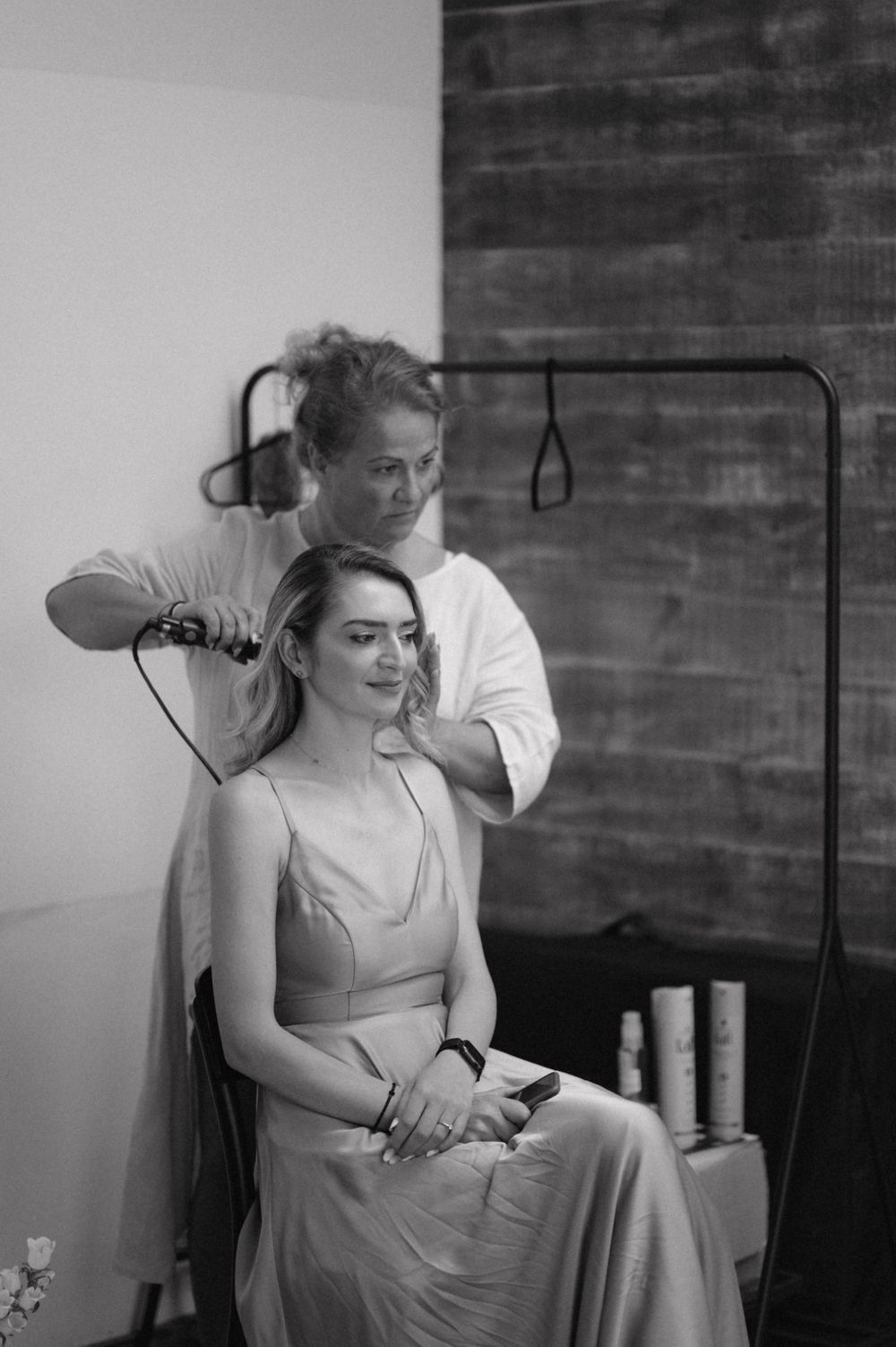 A black and white photo of wedding day hair styling preparation.