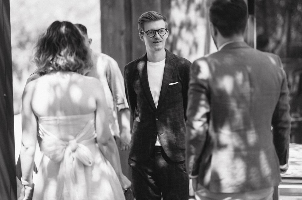 Wedding ceremony scene with dappled sunlight creating shadows through trees.