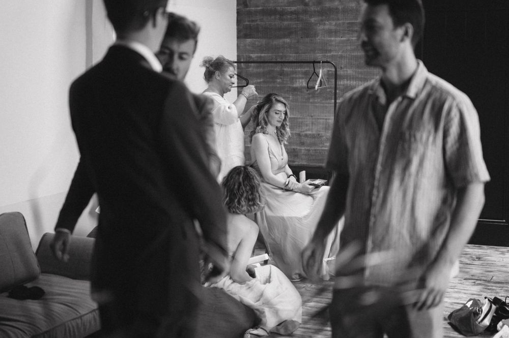 Black and white candid photo of people gathering in an indoor setting.