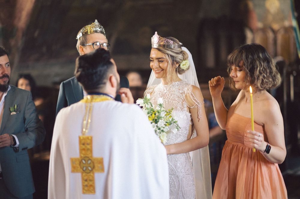 A wedding ceremony unfolds in a traditional Orthodox church with attendants in formal attire.
