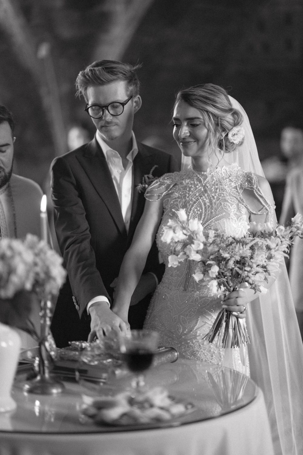 Intimate wedding moment at reception table with elegant floral arrangements.