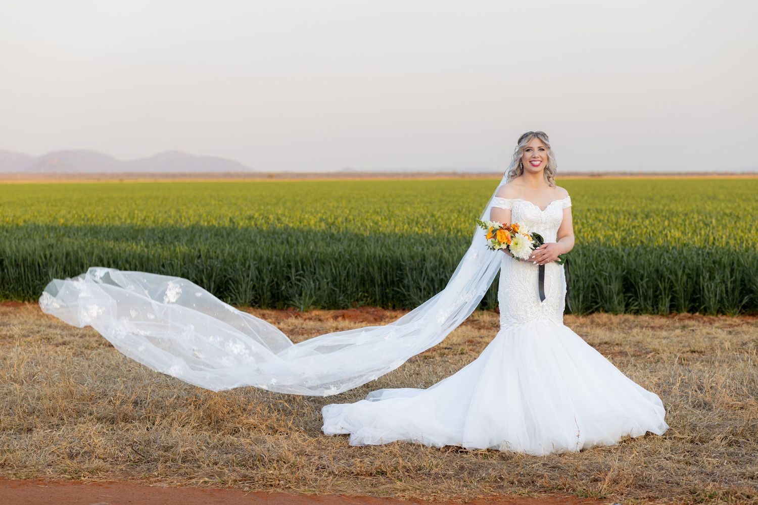 Bride standing with flowing veil during wedding portraits in Pretoria with natural, elegant style and open countryside views