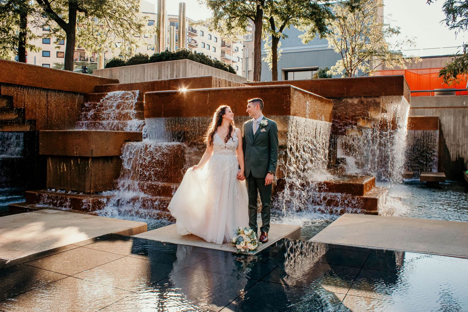 Elegant bridal portraits by a luxurious pool and waterfall feature.